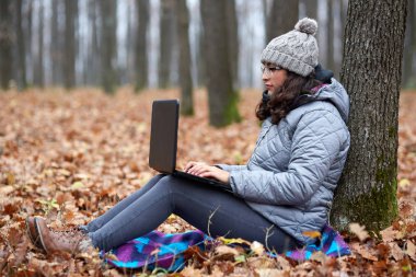 ormanda dizüstü kullanarak iş kadını