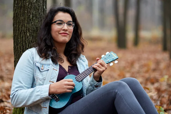 Menina jogando ukulele na floresta — Fotografia de Stock