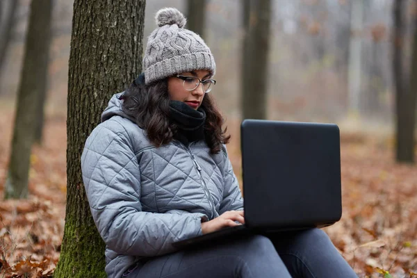 Kobieta korzysta z laptopa w lesie — Zdjęcie stockowe