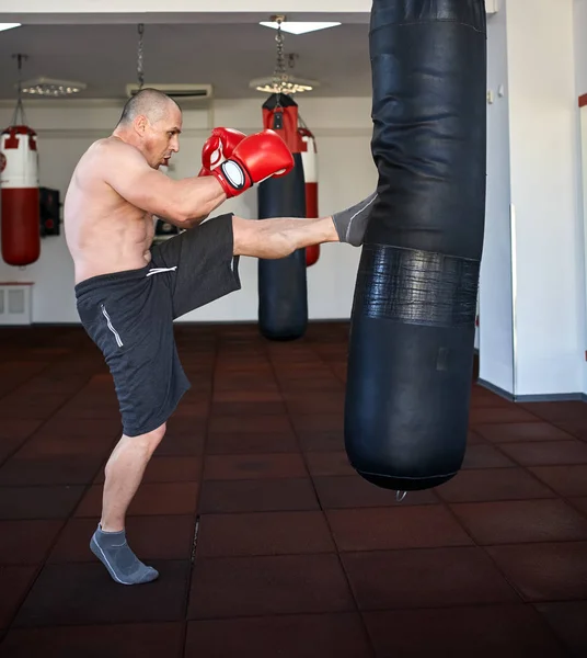 Kickbox-Kämpfer arbeitet an Boxsäcken — Stockfoto