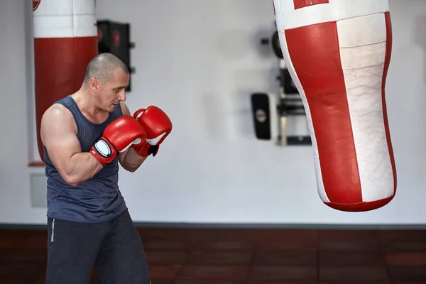 Hombre trabajando en sacos de boxeo — Foto de Stock