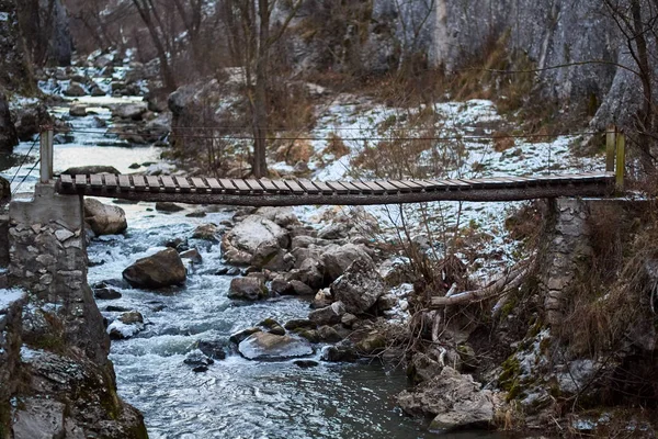 Holzbrücke in einer Schlucht, Winterzeit — Stockfoto