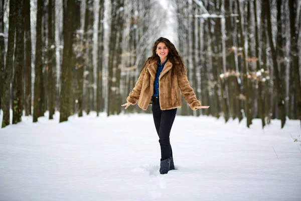 Jonge vrouw buiten in het besneeuwde park — Stockfoto