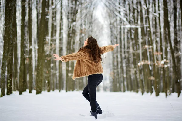 Jonge vrouw buiten in het besneeuwde park — Stockfoto