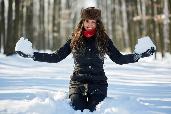 Młoda kobieta gra na śniegu w parku — Zdjęcie stockowe