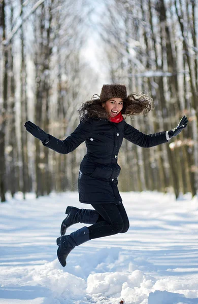 Mulher pulando de alegria na neve — Fotografia de Stock