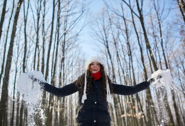 Молода жінка грає зі снігом у парку — стокове фото
