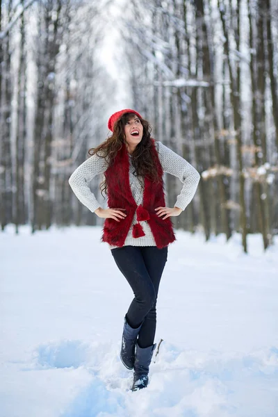 Νεαρή γυναίκα που είναι εξωτερική στο χιονισμένο πάρκο Φωτογραφία Αρχείου