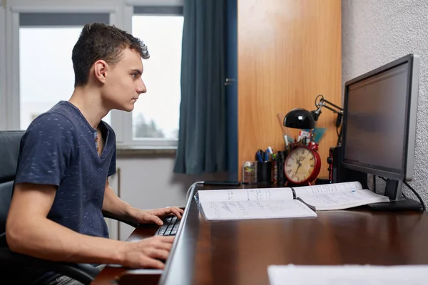 Teenager doing homework with computer — Stock Photo, Image