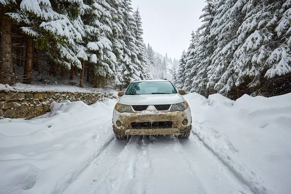 Carro em uma estrada nevada nas montanhas — Fotografia de Stock