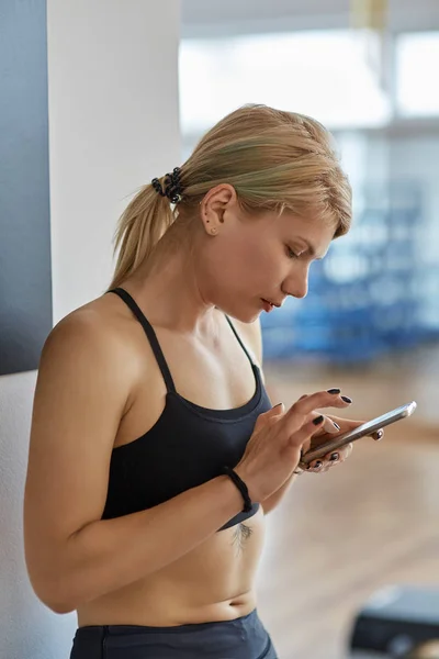 Fitness coach checking her appointments on cellphone — Stock Photo, Image