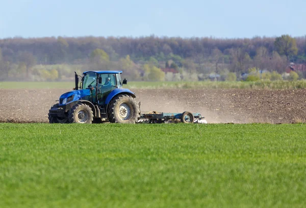 Tractor harrowing the land — Stock Photo, Image