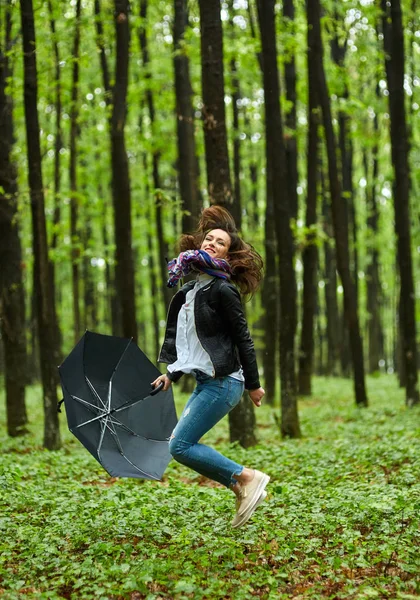 Donna con ombrellone che salta nel parco — Foto Stock