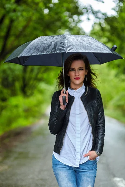 Woman with umbrella in park — Stock Photo, Image