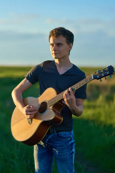 麦畑でギターを弾く少年 — ストック写真