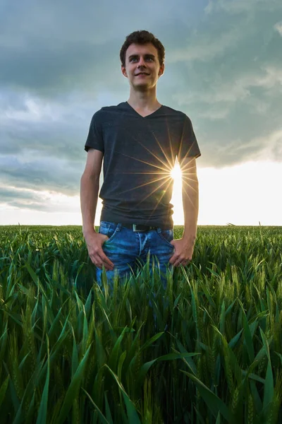 Teenager steht im Weizenfeld — Stockfoto