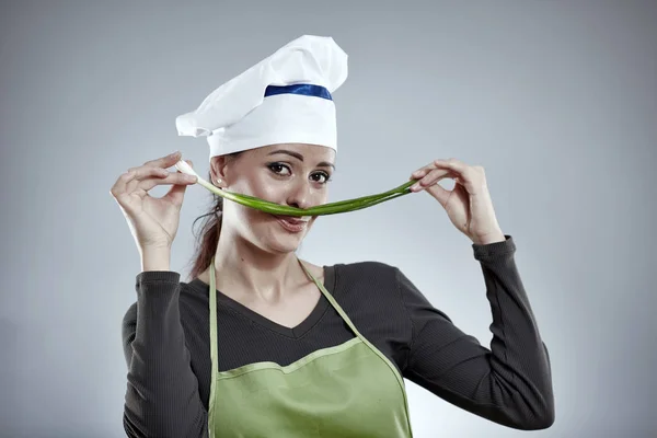 Femme cuisinier avec oignon de printemps — Photo