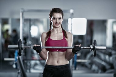 Genç kadının barbell curl yapması