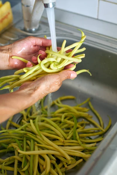 Donna lavaggio cialde di fagioli — Foto Stock