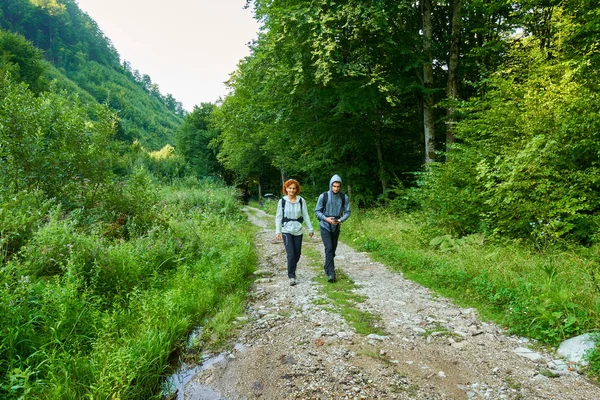 Hikers with backpacks walking on trail — Stock Photo, Image