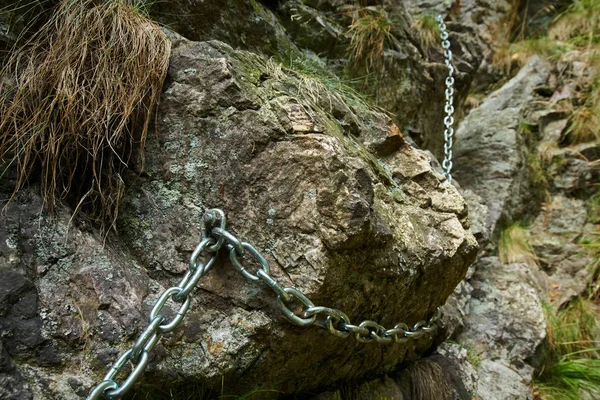 Safety chain hanging on boulders — Stock Photo, Image