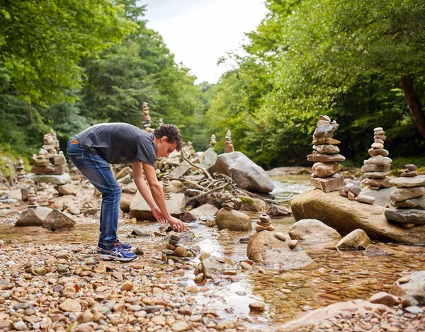 Boy making towers of stones — Stock Photo, Image