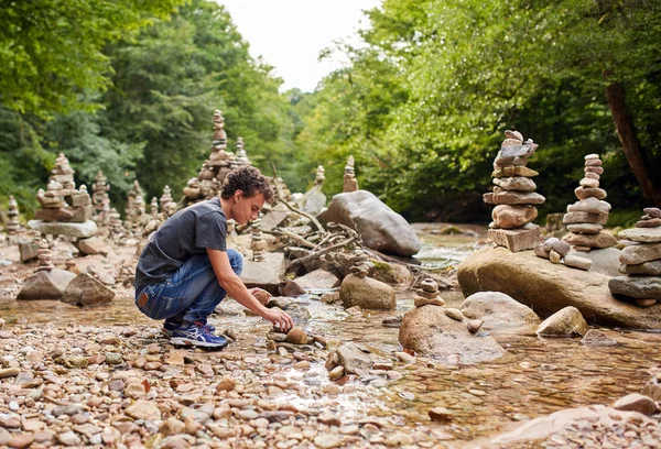 Junge baut Türme aus Steinen — Stockfoto