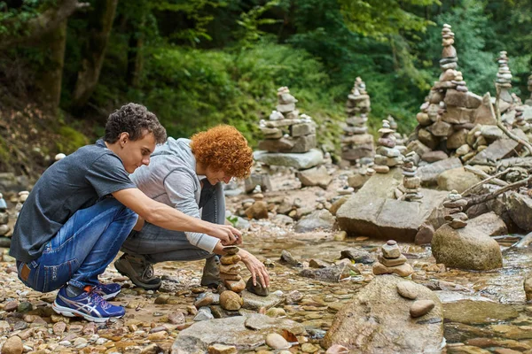 Junge und Mutter bauen Steintürme — Stockfoto