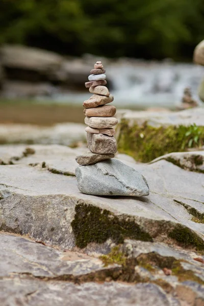 Tower of pebbles near river bank — Stock Photo, Image