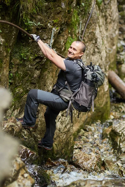 Hombre escalando en cadenas de seguridad — Foto de Stock