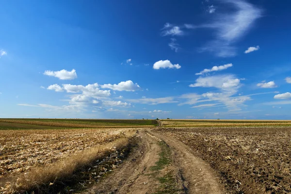 Estrada rural através de campos arados — Fotografia de Stock