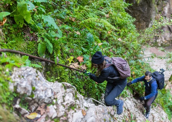 Hikers climbing on safety cable — Stock Photo, Image