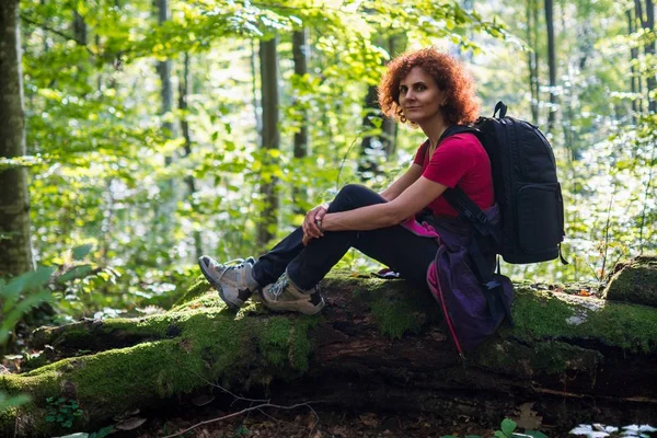 Escursionista donna seduta sul tronco — Foto Stock