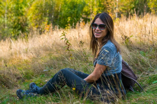 Vrouwelijke wandelaar zittend op het gras — Stockfoto