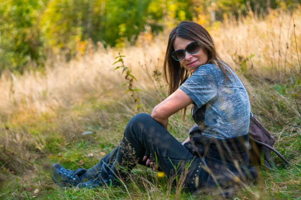 Kobiece wycieczkowicz siedząc na trawie — Zdjęcie stockowe