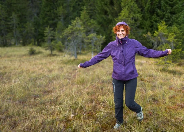 Gelukkig vrouwelijke wandelaar in veld — Stockfoto