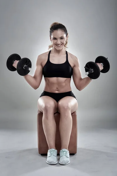 Young woman doing biceps curl — Stock Photo, Image