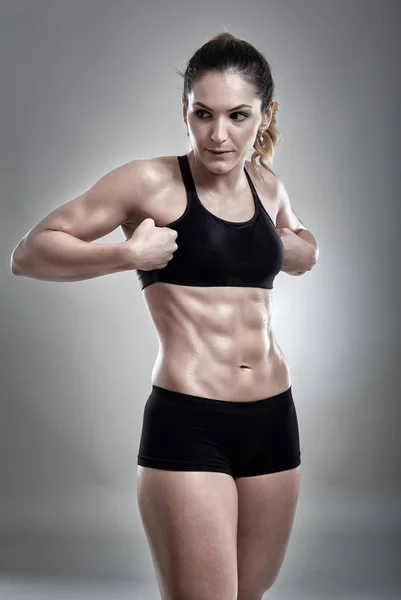 Fitness kvinna poserar i gym outfit Stockfoto