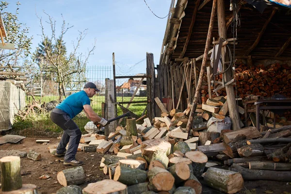 Homem rachando troncos de madeira — Fotografia de Stock