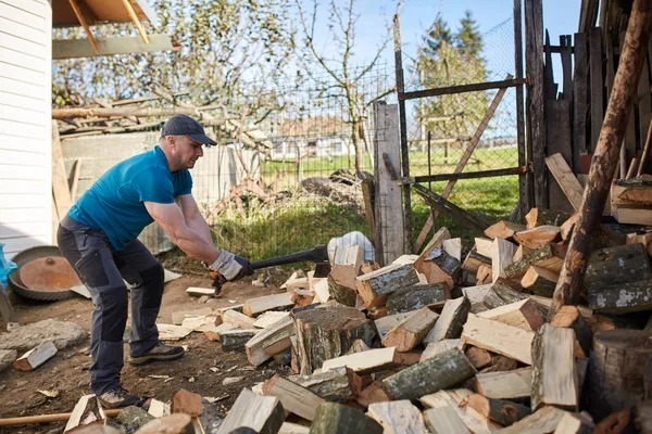 Человек, расщепляющий деревянные бревна — стоковое фото