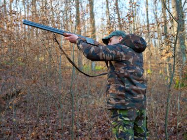 Hunter çift namlulu av tüfeği ile kamuflaj elbiseli