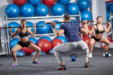 Fitness Eğitmeni ve bacaklar için fitbar egzersiz yapıyor öğrenciler