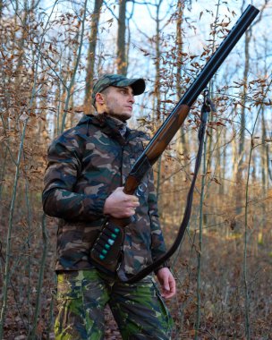 Hunter çift namlulu av tüfeği ile kamuflaj elbiseli