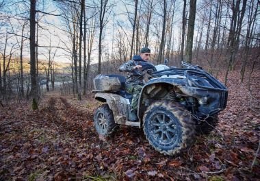 Ormanın içinde oyun için arama bir quad bisiklet üzerinde genç avcı