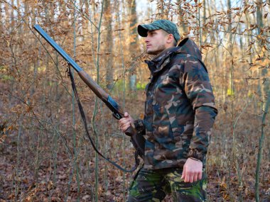 Hunter çift namlulu av tüfeği ile kamuflaj elbiseli