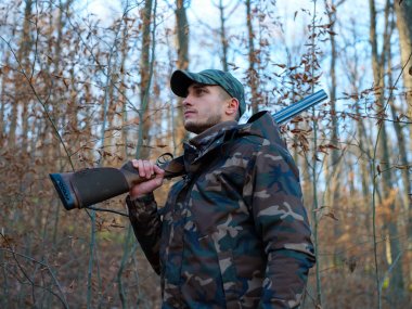 Hunter çift namlulu av tüfeği ile kamuflaj elbiseli