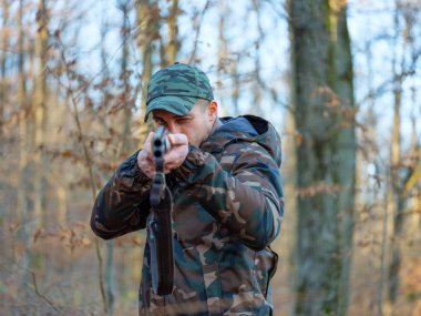 Hunter çift namlulu av tüfeği ile kamuflaj elbiseli