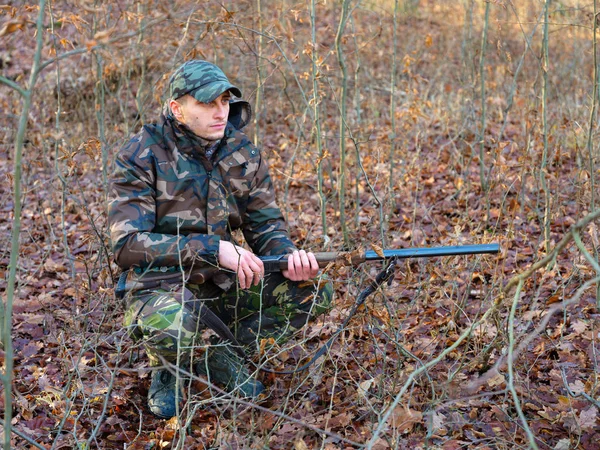 Hunter çift namlulu av tüfeği ile kamuflaj elbiseli