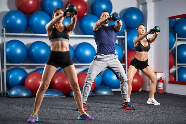 Fitness Eğitmeni kettlebell ile çalışma dışarı iki kızla