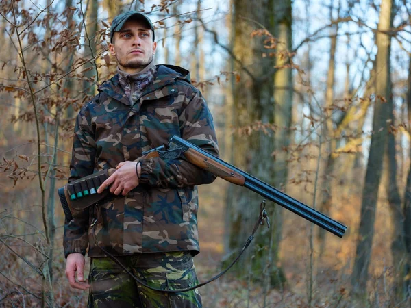 Hunter çift namlulu av tüfeği ile kamuflaj elbiseli